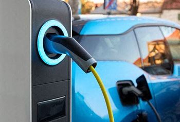 a blue car is parked next to an electric charger